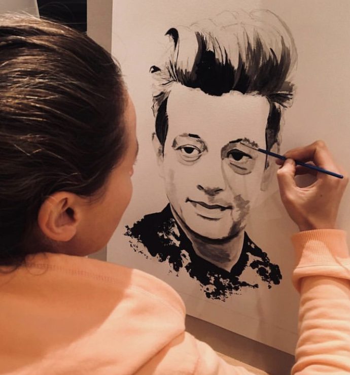 Vanessa Talleux peignant un portrait en noir et blanc dans son atelier