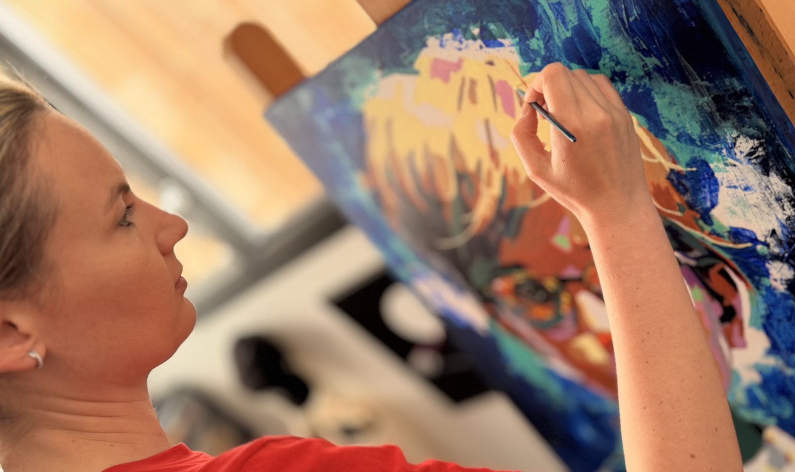 Vanessa Talleux de profil, peignant le portrait AUBIN dans son atelier