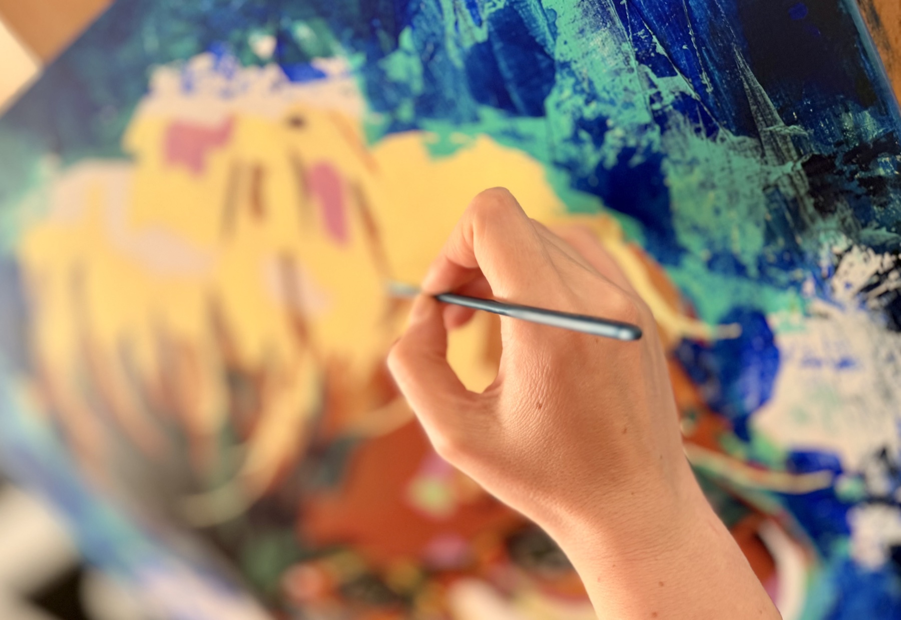 La main et le pinceau de Vanessa Talleux sur la toile en cours